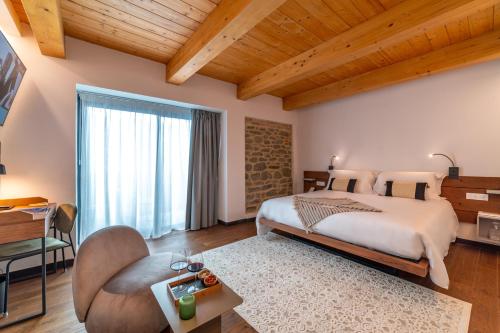 a bedroom with a king sized bed and a table at Via Roma 33 Tuscany Boutique Hotel & Spa - Adults Only in Stia