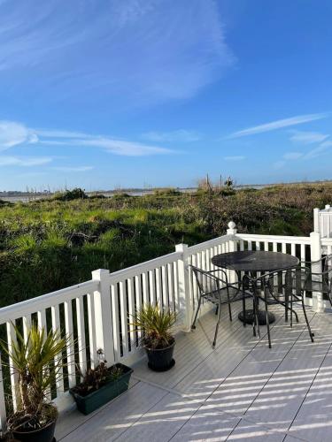 a patio with a table and chairs on a white fence at Harbour Escape - Church Farm in Pagham