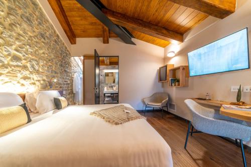 a bedroom with a large bed and a stone wall at Via Roma 33 Tuscany Boutique Hotel & Spa - Adults Only in Stia