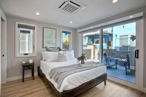 a bedroom with a large bed and a balcony at NEW Luxury Beach Home I 3BR I Balcony I Firepit in San Diego