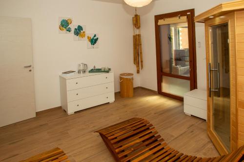 um quarto com uma cadeira, uma cómoda e um espelho em Modern Villa with jacuzzi and sauna near Tuscany em Monghidoro