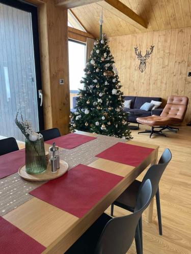 a christmas tree in a room with a table and chairs at Luxury Chalet Telgart in Telgárt