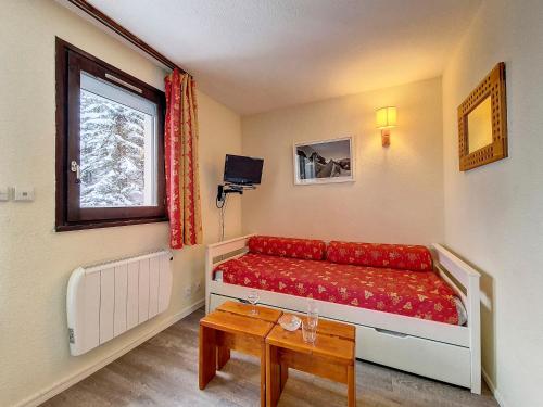 une chambre avec un canapé rouge et une fenêtre dans l'établissement Studio cosy au pied des pistes avec balcon à 24 Rue du Panorama, Les Belleville - FR-1-344-884, aux Menuires