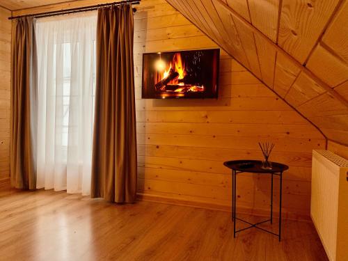 a living room with a fireplace in a log cabin at Bilychi - садиба у Карпатах in Bilichi