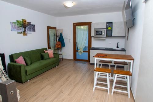 a living room with a green couch and a kitchen at Villa Sumbilla, Modern, with sauna, heated jacuzzi near Tuscany in Monghidoro
