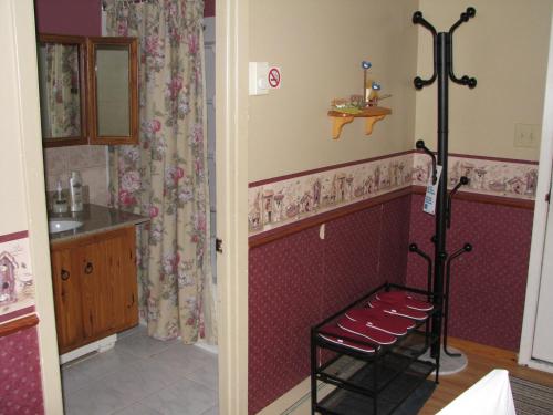 a bathroom with a sink and a chair in a room at Motel Le Charentais in Sorel