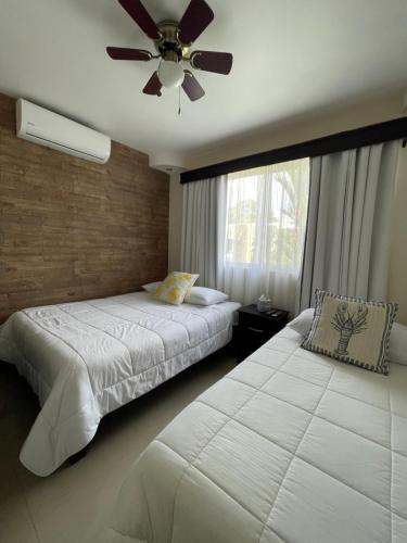 a bedroom with two beds and a ceiling fan at Casa Encanto Luz del Mar, Con Piscina Privada in Herradura