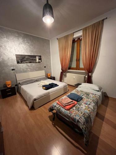 1 dormitorio con 2 camas y ventana en Matilda’s Apartment, en Strambino