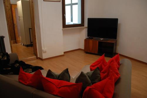 ein Wohnzimmer mit einem Sofa und roten Kissen in der Unterkunft Ca de Vej in Nus