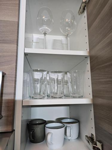 a cupboard with wine glasses and other glass items at Modern Studio near Düsseldorf Airport & Messe/Fair in Meerbusch