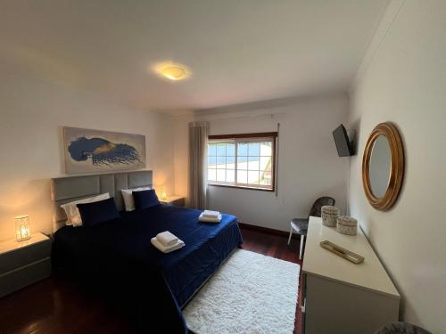 AM Residence في براغا: غرفة نوم بسرير ازرق ونافذة