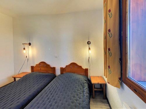 une chambre avec deux lits et une fenêtre dans l'établissement Appartement chaleureux, pied des pistes, balcon, 4 pers. - FR-1-267-208, au Corbier