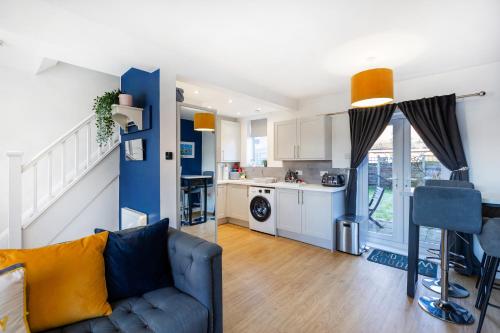 uma sala de estar com um sofá e uma cozinha em The Heart - Cosy 3 bedroom house with double driveway and Garden in Manchester em Manchester