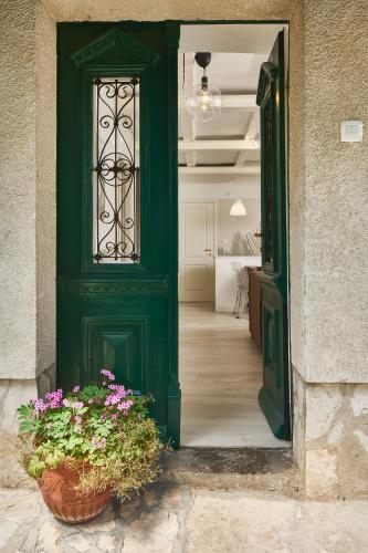 a green door with two potted plants in a hallway at Secret Garden Apartment Center Opatija with private parking space in Opatija