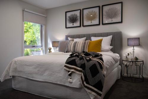 a bedroom with a large white bed with pillows at Daylesford Spa Villa 5 in Daylesford
