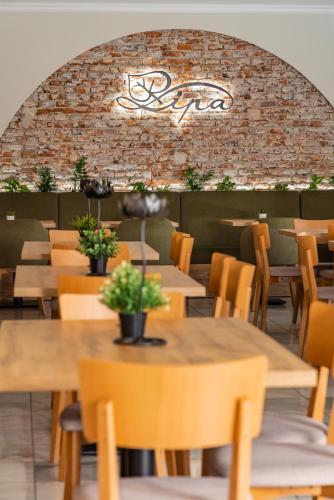 a restaurant with tables and chairs and a brick wall at Hotel Lipa in Bojnice