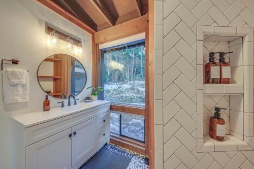 a bathroom with a sink and a mirror and a window at Bonners Ferry Cabin with Wraparound Deck and Views! in Bonners Ferry