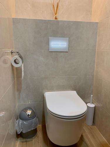a bathroom with a toilet and a trash can at Bilychi - садиба у Карпатах in Bilichi