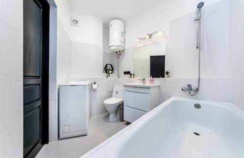 bagno bianco con vasca e servizi igienici di Modern 1 bedroom apartment a Kiev