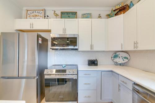a kitchen with white cabinets and a stainless steel refrigerator at Family-Friendly Crystal Beach Home Steps to Beach in Crystal Beach