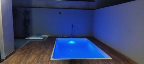 a room with a blue table on a wooden floor at Recanto da Tairine in Olímpia