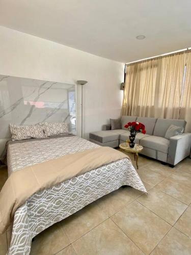 キトにあるSuite Independiente e íntima al Norte de Quitoのベッドルーム(ベッド1台、ソファ付)
