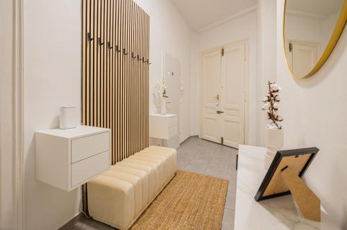 a white bathroom with a bench and a mirror at Charming APT perfect for 4-6 tram, self-checkin in Vienna