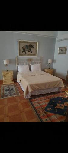 a bedroom with a large bed and two night stands at Soliman Villa in Luxor