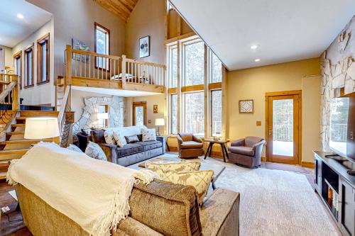 a living room with a couch and a staircase at Hidden River Lodge in Eagle River