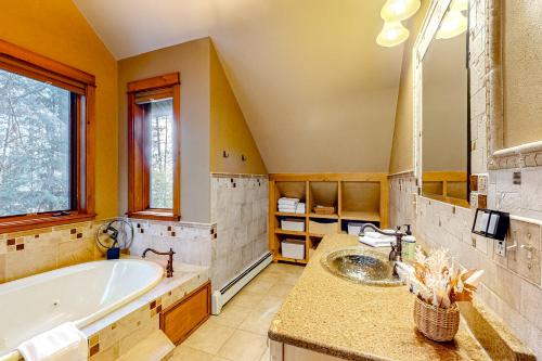 a bathroom with a tub and a sink at Hidden River Lodge in Eagle River