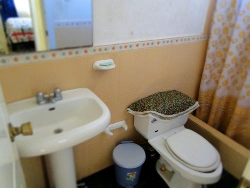 ein kleines Bad mit WC und Waschbecken in der Unterkunft GUESTHOUSE MOUNTAIN TRAVEL ECUADOR 