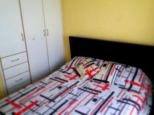 a bedroom with a bed with a plaid bedspread at GUESTHOUSE MOUNTAIN TRAVEL ECUADOR 