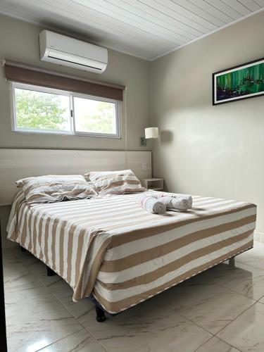 a bedroom with a large bed with a striped blanket at Hotel Mola in Puerto Iguazú