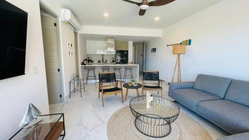 Playa Medano Caminando, Alberca en el roof في كابو سان لوكاس: غرفة معيشة مع أريكة زرقاء وطاولة