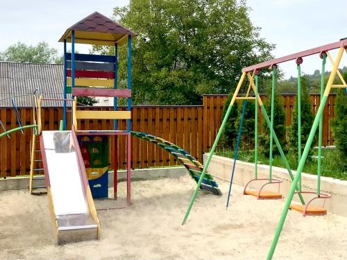 a playground with two swings and a slide at Bilychi - садиба у Карпатах in Bilichi