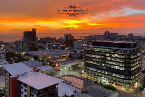 a city skyline with a sunset in the background at "NEWQUAY" Ideal Location & Views at PenthousePads in Darwin