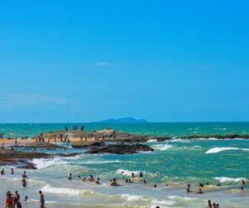 a group of people on a beach near the ocean at Casa Via Sol, Rio das Ostras in Rio das Ostras