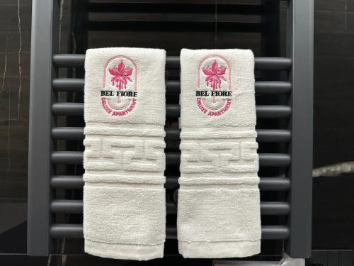 two towels with the red force logo on them at Bel Fiore Deluxe Apartment in Genova