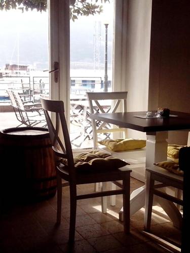a dining room with a table and chairs and a window at Stanica B&B in Herceg-Novi