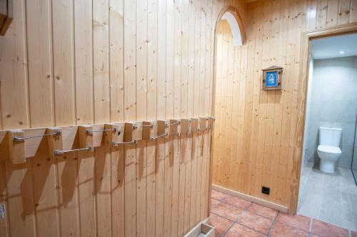 Un baño con paredes de madera y un inodoro. en EUROPA HOUSE - Parking GRATIS, en Sierra Nevada