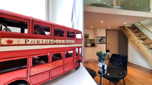 a red double decker bus on display in a room at Cool new Notting Hill apt - 2 mins to Portobello in London