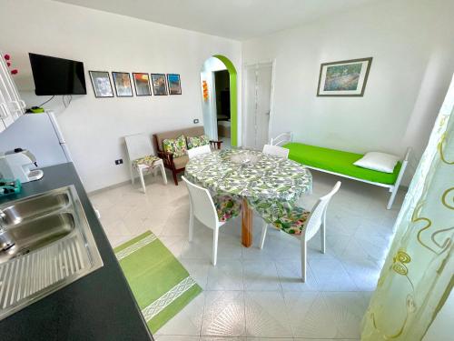 a kitchen and living room with a table and chairs at ChiarAmare Vacanza, casa con Idromassaggio, vicino Maldive del Salento in Torre Pali 