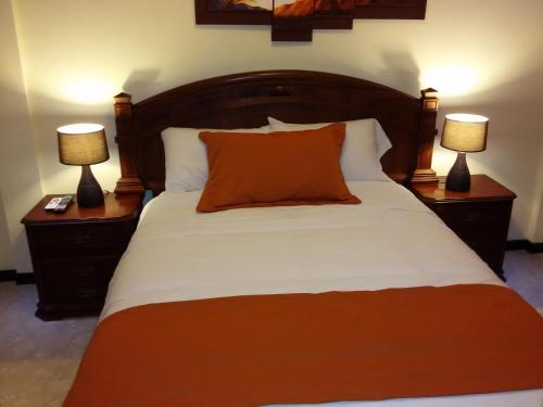a bedroom with a bed with two lamps on night stands at Hotel Las Mercedes Airport-Quito in Tababela