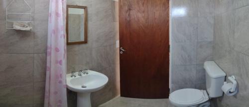 een badkamer met een wastafel, een toilet en een douche bij Vista del Lago in Villa Carlos Paz