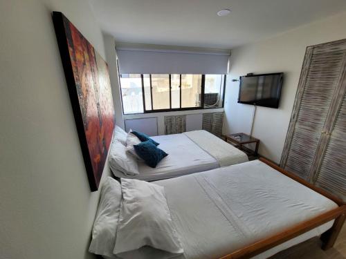 a bedroom with two beds and a window at Edificio Marina del Rey Cartagena in Cartagena de Indias