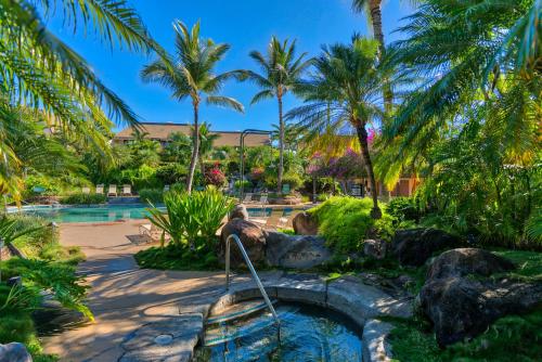 a pool with palm trees and a hot tub at Maui Kamaole in Wailea