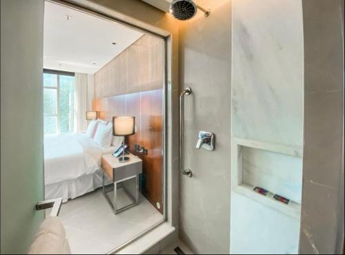uma casa de banho com um chuveiro, uma cama e um espelho. em Hotel nacional no Rio de Janeiro