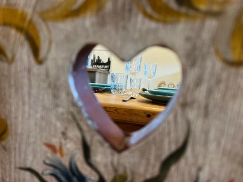 a wooden table with glasses in a heart shaped mirror at Ferienwohnung im Sonnendorf Öblarn in Öblarn