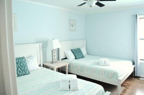 two beds in a room with blue walls at Living the Dream on the beach! in Carolina Beach