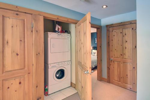 a laundry room with a washer and dryer at Chalet des Pionniers SPA, BBQ, JEUX in Labelle